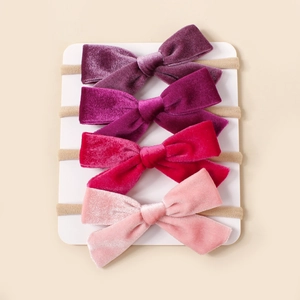 Détail de quatre bandeaux à nœuds en velours tons violets et roses sur support