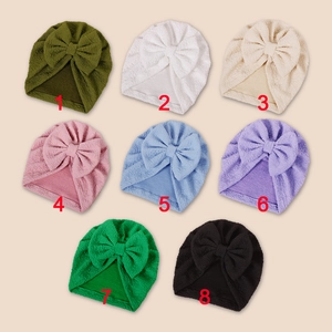 Detailed view of baby turban hats with large bows in eight vibrant assorted colors