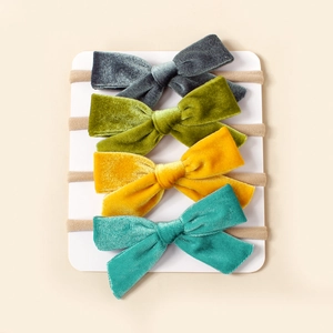 Détail de quatre bandeaux bébé avec nœuds en velours de couleurs assorties