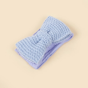 Detailed macro view of soft knit texture on a light blue bow headband for babies