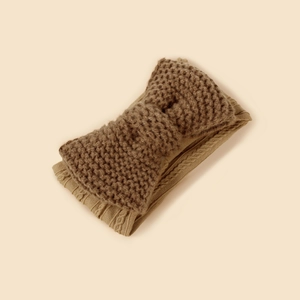 Detail shot of camel knitted baby headband featuring a double-layered bow and thick texture
