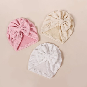 Three bow-knot baby turbans in pink, beige, and white with textured bubble cotton fabric
