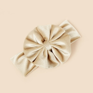 Détail du bandeau bébé en velours champagne avec un grand nœud plissé élégant