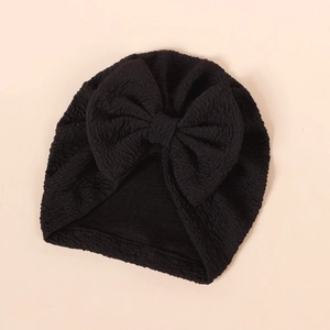 Detailed texture of black bubble fabric baby turban with a large decorative bow