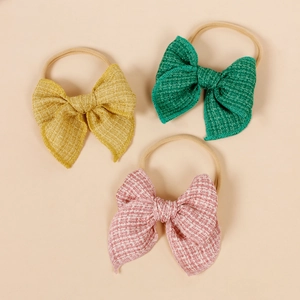 Détail de trois bandeaux élastiques pour bébé avec des nœuds en tissu texturé