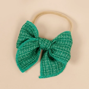 Détail d'un bandeau à nœud en tweed vert émeraude avec bande en nylon beige doux