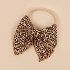 Détail du nœud en tweed montrant la texture complexe du tissu tissé noir et or