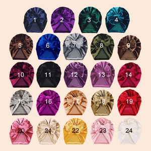 Selection of 24 colorful baby velvet turban hats with large bows displayed in a grid