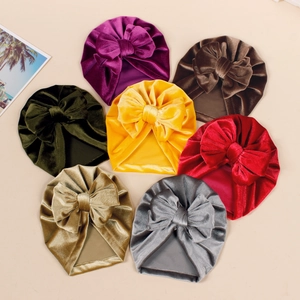 Set of seven velvet baby turban hats with large bows in assorted warm colors
