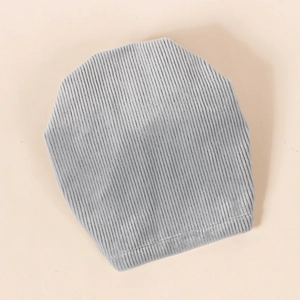 Bonnet en velours côtelé gris clair pour bébé avec texture côtelée sur fond orange