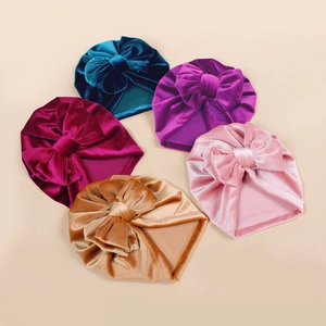 Detail of five assorted colors of velvet baby headbands with large bows for infants