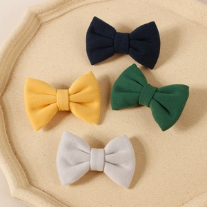 Detailed texture of felt bow hair clips in navy, green, yellow and grey colors