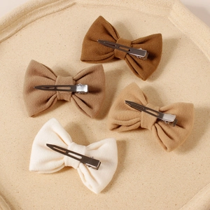 Four piece set of girl's cashmere hair bows in warm earthy tones with metal clips