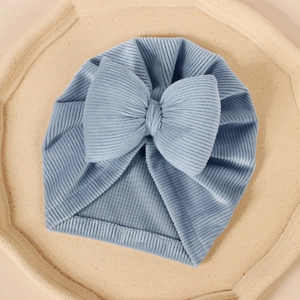 Détail de la texture du turban pour bébé bleu clair en velours avec un grand nœud