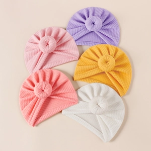 Detail of ribbed knit baby donut turbans in purple, pink, coral, yellow, and white colors