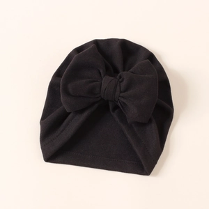 Detailed close-up of a soft black infant turban hat featuring a large decorative bow
