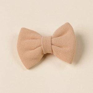 Detail showing the fiber texture and soft fabric of this beige bow hair clip for girls