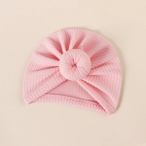 Close-up of pink waffle texture baby donut hat with soft ribbed knit fabric details