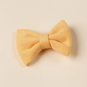 Detail of yellow plush bow hair clip for girls with soft velvet texture and central knot