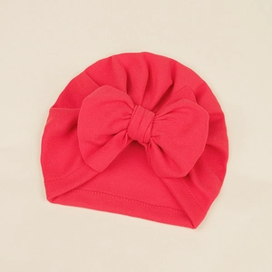 Macro detail of red baby turban hat with large bow and soft ribbed knit texture