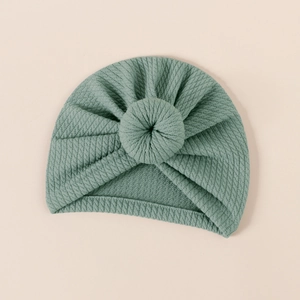 Close-up of the ribbed texture and donut knot on this sage green baby turban hat