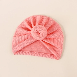 Detail view of pink ribbed knit baby turban featuring a soft donut knot design