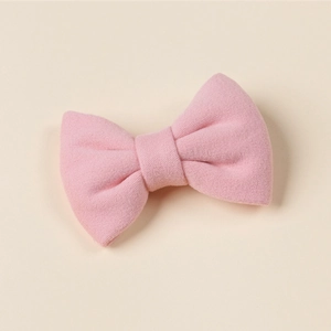 Detailed view of pink knitted bow hair clip featuring premium wool texture and fabric