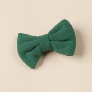 Detailed view of the dark green cashmere-like bow hair clip for girls with fine fabric texture