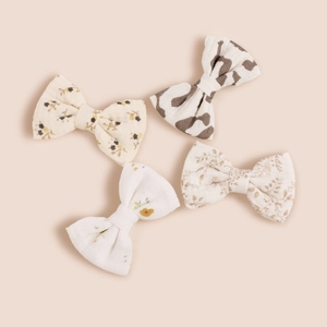Détail de quatre barrettes nœuds en coton avec motifs floraux et imprimés animaliers