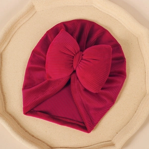 Détail de la texture du turban pour bébé avec grand nœud sur un fond de pierre