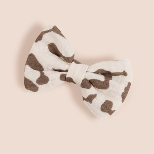 Vue détaillée d'un nœud à cheveux en coton crème avec un imprimé vache marron élégant
