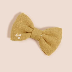 Détail d'un nœud à cheveux en coton jaune avec broderie cerise blanche délicate