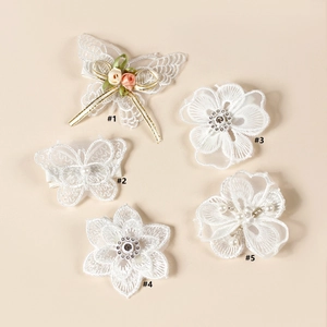Vue détaillée des barrettes en dentelle blanche faites main avec perles et broderies