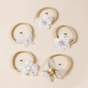 Détail de l'ensemble 5 bandeaux pour bébé avec fleurs en dentelle et perles sur nylon