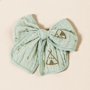 Detailed close-up of mint green gauze hair bow with simple teepee print and lock-stitched edges