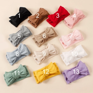Collection de 13 bandeaux bébé colorés avec nœuds en tricot jacquard sur fond beige