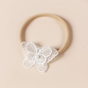 Vue détaillée du bandeau en dentelle blanche brodée avec perle pour nouveau-né