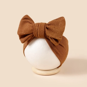 Détail du bandeau bébé en maille jacquard marron chaud avec grand nœud double épaisseur
