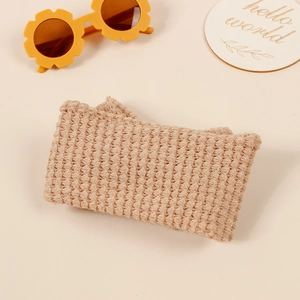Knitted double layer bow baby headband with soft waffle texture on warm beige background