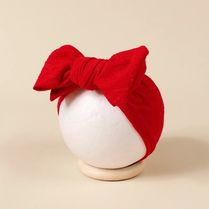Gros plan du bandeau bébé rouge en tissu gaufré avec un grand nœud double couche