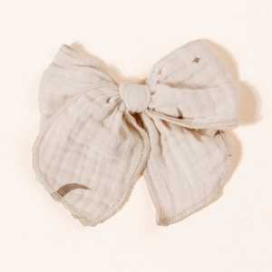 Close-up of off-white muslin hair bow with star and moon print for children