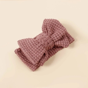 Detail of knitted dusty rose double layer bow headband with thick crochet texture