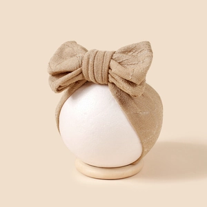 Vue détaillée du bandeau pour bébé pailleté or champagne avec un double nœud jacquard