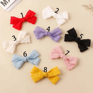 Detailed overhead view of 8 colorful embroidered lace bow hair clips for girls