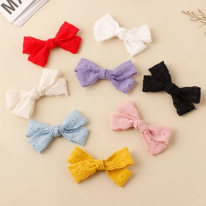 Flat lay of eight colorful lace bow hair clips with embroidered floral hollow patterns