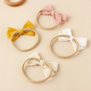 Set mit vier Baby-Stirnbändern aus Nylon mit feinen Spitzenschleifen in Rosa und Gelb