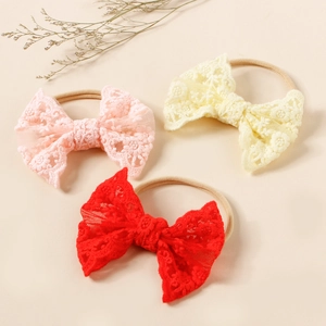 Detailed view of delicate lace bow headbands with soft elastic nylon bands for babies