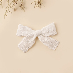 Detailed macro view of white lace butterfly hair clip with floral embroidery