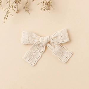 Close-up of cream lace embroidery butterfly hair clip with delicate floral patterns