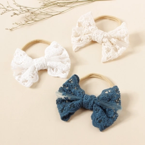 Detail of baby lace bow headbands with floral embroidery and high elastic nylon straps